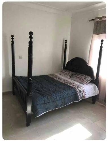 a bed with a black frame in a bedroom at Kareber Solo in Gulu