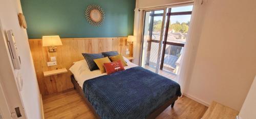 a bedroom with a bed with blue sheets and a window at Hyper-centre et bord de mer avec clim et parking! in Arcachon