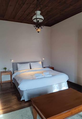 a bedroom with a large white bed and a table at En Chora Vezitsa in Vitsa