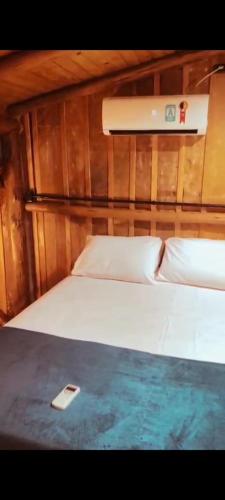 un lit dans un bateau avec un téléphone portable dessus dans l'établissement Bella Vista, à Imbituba