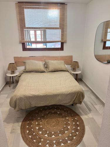 a bedroom with a bed with two tables and a window at Apartamento Doña Pia Mijas in Mijas