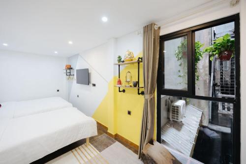 a small room with a bed and a window at Rik Homestay in Hanoi