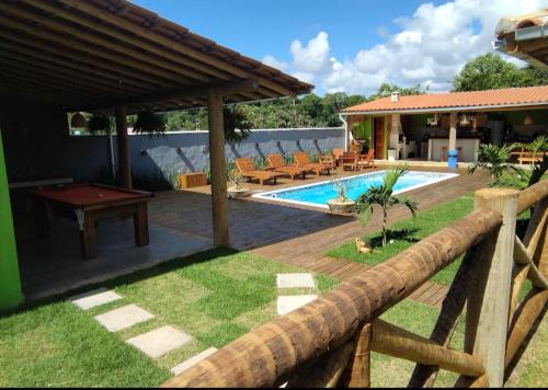 een achtertuin met een zwembad en een houten hek bij Rancho Bela Vista Sapirara in Trancoso