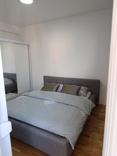 a bed in a bedroom with a white wall at Stan na dan Brcko -The Gold Nook in Brčko