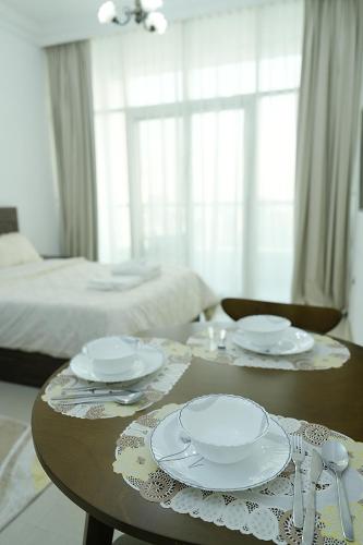 a table with plates and napkins on top of it at Cozy Private Studio -Near Beach -City View -Downtown Sharjah - Pool & Gym in Sharjah