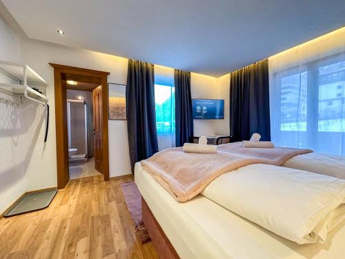 a bedroom with two beds and a large window at Luna Studios Zillertal in Hippach