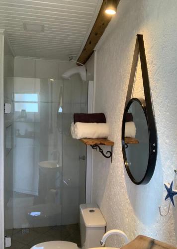 La salle de bains est pourvue d'un miroir, d'un lavabo et de toilettes. dans l'établissement Bella Vista, à Imbituba
