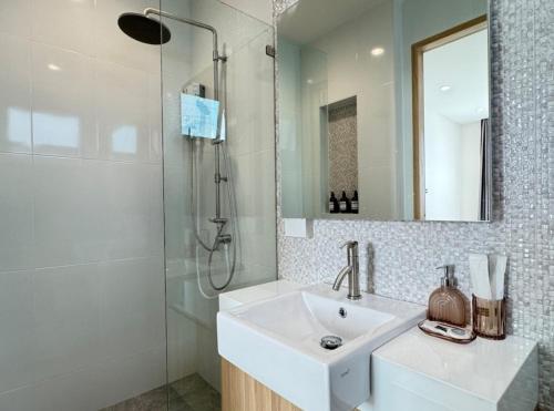 a white bathroom with a sink and a shower at Stay Tuned Pool Villa in Pattaya in Ban Huai Yai