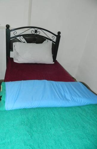 a bed with a red and blue blanket and white pillows at GITE DETAPE DAR AGSWAL DOUAR WANSKRA OUED IMNANE ASNI MARRAKECh in Tacheddirt