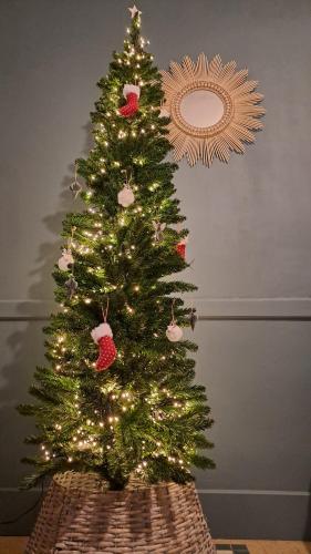 un arbre de Noël orné de lumières et d'ornements dans l'établissement Maison de vacances vue mer, à Pornic