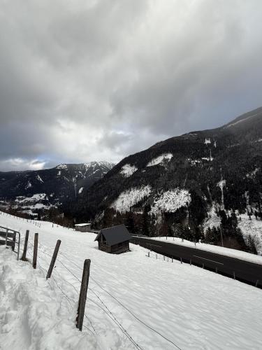 a snow covered mountain with a barn in the distance at Dark Sky TWO in Kleinsölk