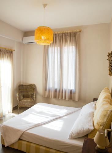 a bedroom with a large white bed and a window at Prokymaia Penthouse Apartment in Rethymno
