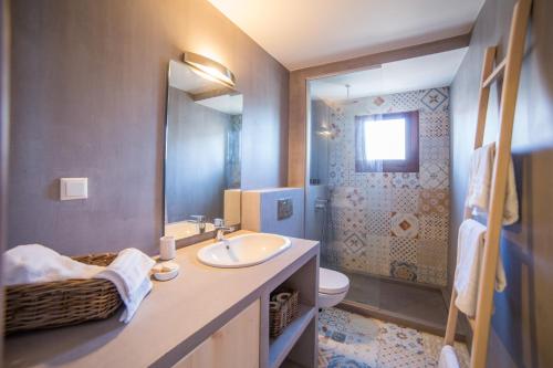 a bathroom with a sink and a toilet and a mirror at Prokymaia Penthouse Apartment in Rethymno