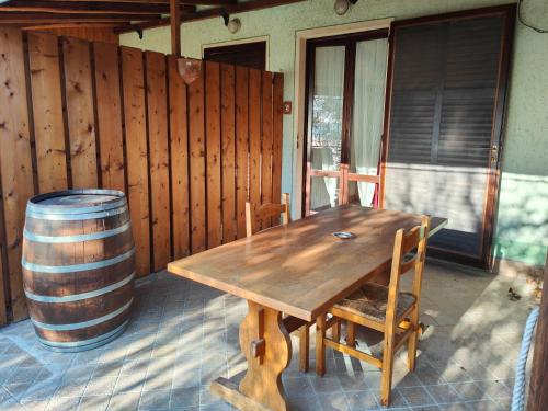 a wooden table and chairs on a patio with a barrel at Agriturismo Scuderia Castello in Gaino