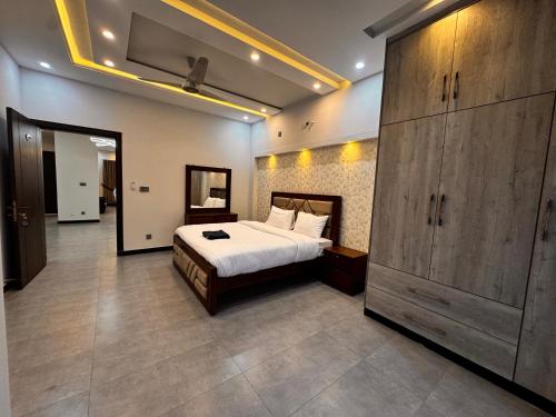 a bedroom with a large bed and a large cabinet at Bridge Residency-2 Top City-1 Islamabad in Islamabad