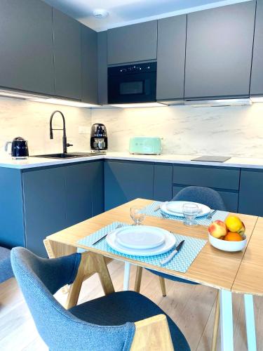 - une cuisine avec une table en bois et un bol de fruits dans l'établissement HOSSEGOR Plage & Golf, à Hossegor