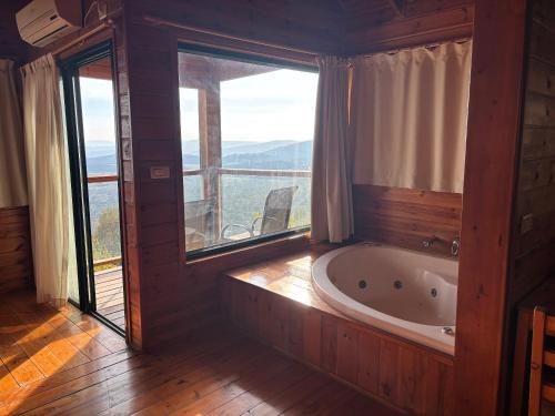 a bath tub in a room with a large window at לוין נוף מרהיב in Amirim