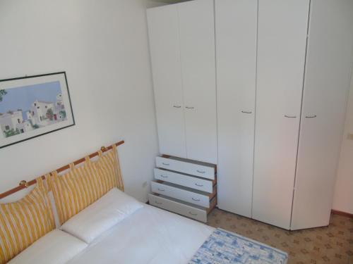 リニャーノ・サッビアドーロにあるCondominio Nazioniのベッドルーム1室(ベッド1台、白いキャビネット付)