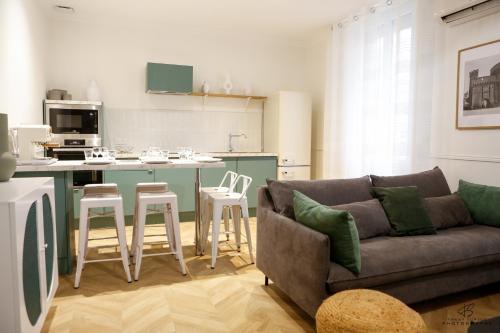 un salon avec un canapé et une cuisine dans l'établissement L'Olivier de Beau Pré - App 1-2 - Centre ville, à Perpignan