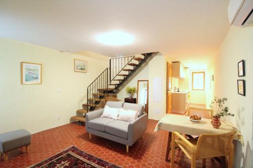 un salon avec un canapé et un escalier dans l'établissement Casa Giulia - Duplex Eva, à LʼÎle-Rousse