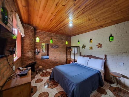 - une chambre avec un lit dans une pièce dotée d'un plafond en bois dans l'établissement Pousada Canto da Serra, à Conceição da Ibitipoca