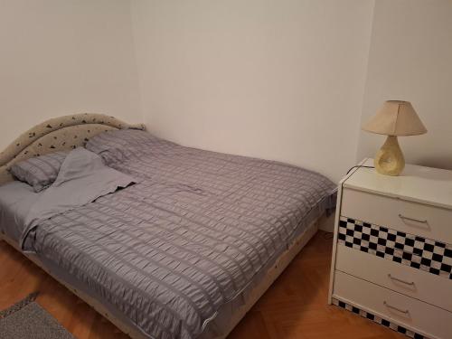 a bedroom with a bed and a nightstand with a lamp at Asami in Vrnjačka Banja