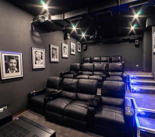 a room with black leather reclining chairs and pictures on the wall at Pinares Vista Lago in Pucón