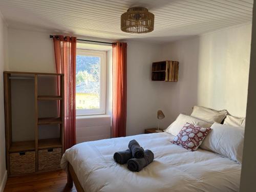 ein Schlafzimmer mit einem Bett mit zwei Hüten darauf in der Unterkunft Appartement tout confort 7 personnes à Porté-Puymorens in Porté-Puymorens