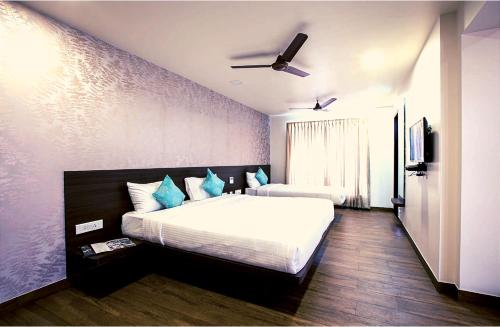 a bedroom with a large bed with blue pillows at HOTEL VINTAGE CASTLE in Coimbatore