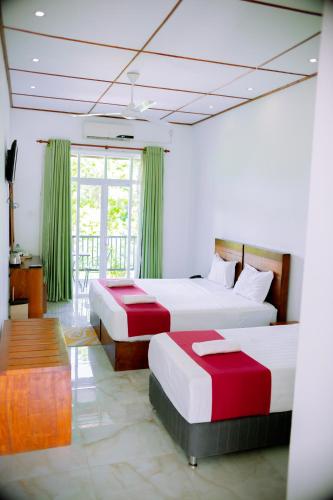 a hotel room with two beds and a balcony at Yala Hotel Elephant Eye in Tissamaharama