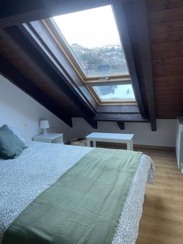 a bedroom with a bed and a large window at El Rincón de las Estrellas in Escarrilla