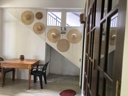 a room with a table and straw hats on the wall at Lisha Mawella in Tangalle