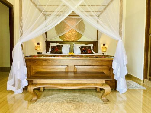 a bedroom with a bed with a canopy at Lisha Mawella in Tangalle
