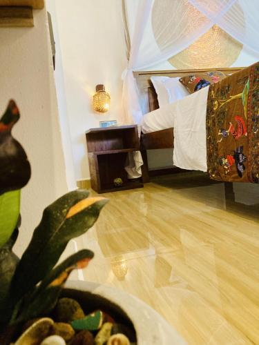 a bedroom with a bed and a plant in the foreground at Lisha Mawella in Tangalle
