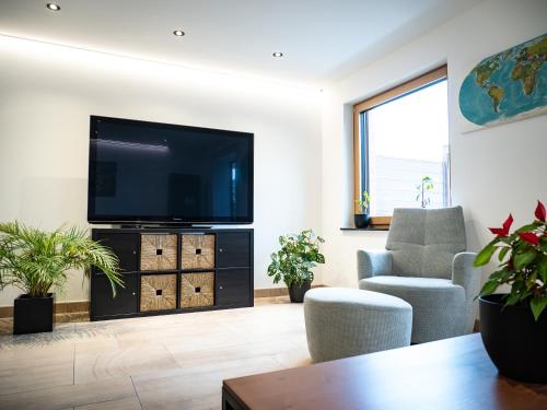 a living room with a flat screen tv on a wall at Haus Wanderlust in Saint-Vith