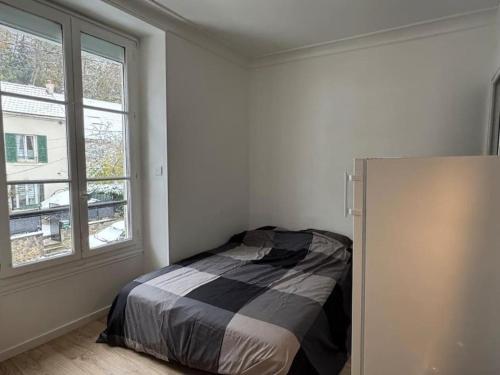 une chambre avec un lit dans une pièce avec une fenêtre dans l'établissement Studio Cosy 1 Chambre Proche Paris & Versailles, à Les-Loges-en-Josas