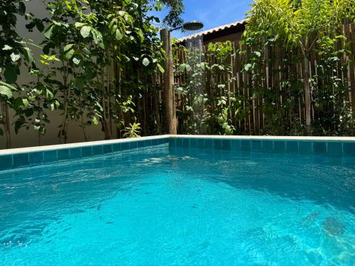 a blue swimming pool in front of a fence at Bahia Soul - Vilas de Maré - Taipu de Fora - Península de Maraú in Marau