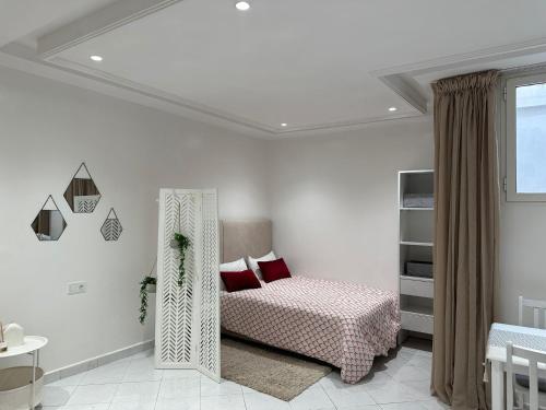 a white bedroom with a bed and a window at charm'Studio au coeur d'Agadir in Agadir