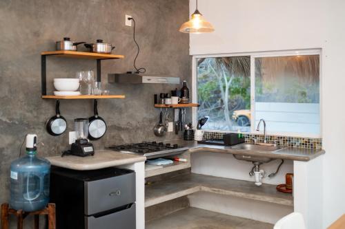 a small kitchen with a sink and a stove at Sayula HoME in Sayulita