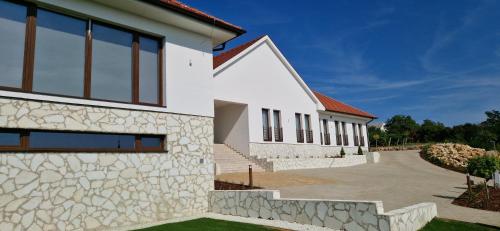 a house with a stone facade and a driveway at Villa Zéta Wine & Spa in Mád