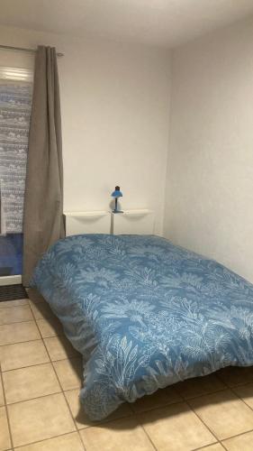 a bedroom with a blue comforter on a bed at Studio 170m Plage de Sable, Clim & Parking in Le Barcarès