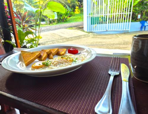 a plate of food on a table next to a fork at Corcovado & Drake Inn in Drake