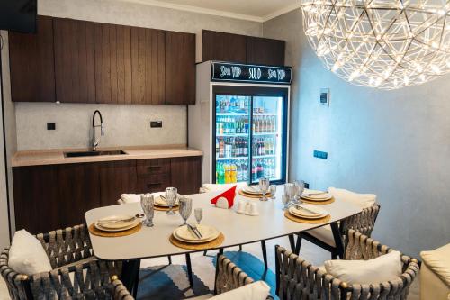 a dining room with a table and chairs and a kitchen at SULO VIP Spa in Atyraū
