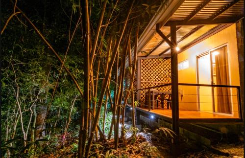 a house with a lit up porch at night at Cabinas La Fulanita in Nicoya