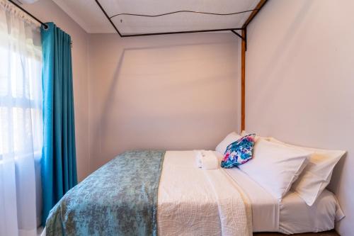 a small bedroom with a bed with a canopy at KhayaLethu Vic Falls in Victoria Falls