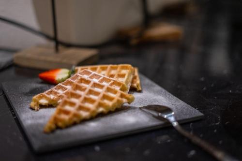 two waffles are sitting on a table with a fork at Boutiquehotel - Michl in Sautens