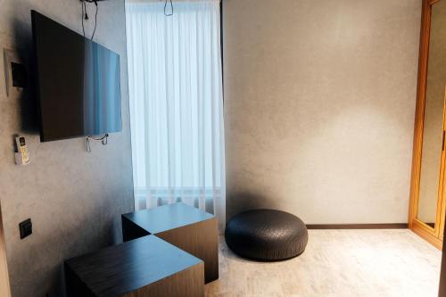 a room with a ottoman sitting next to a television at SULO VIP Spa in Atyraū