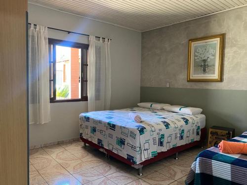 a bedroom with two beds and a window at Casa Gil in Foz do Iguaçu