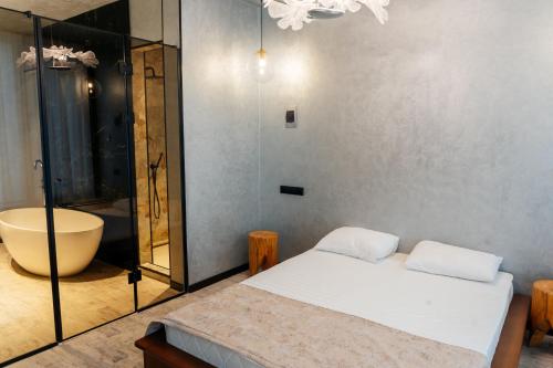 a bedroom with a bed and a bath tub and a tub at SULO VIP Spa in Atyraū