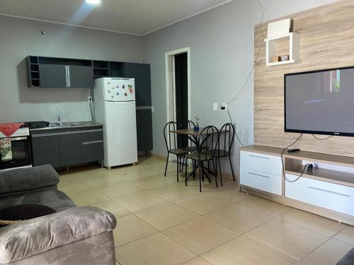 a living room with a refrigerator and a table with chairs at Casa Gil in Foz do Iguaçu